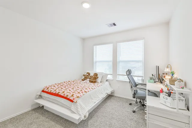 a bedroom with a bed and a table chair