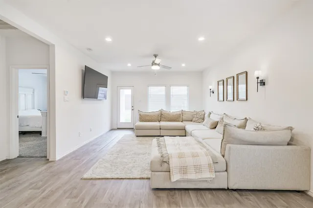 a living room with furniture and a ceiling fan