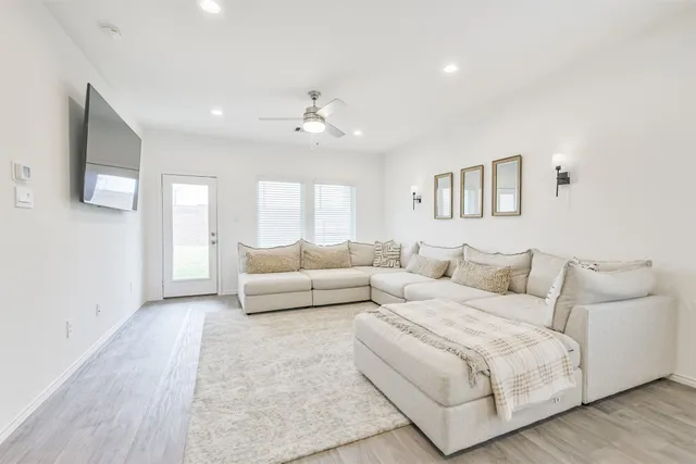 a living room with furniture and a ceiling fan