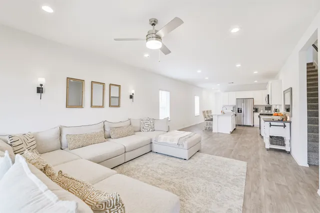 a living room with furniture white walls and chandelier