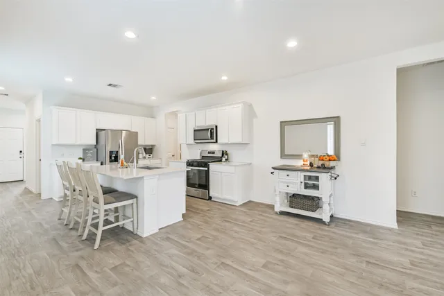 a kitchen with white cabinets and stainless steel appliances