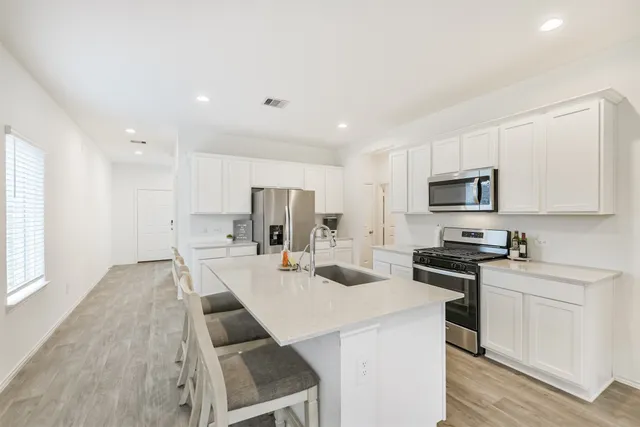 a kitchen with white cabinets and stainless steel appliances