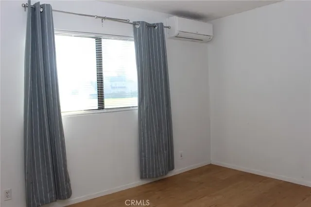 a view of a small space with wooden floor and a window