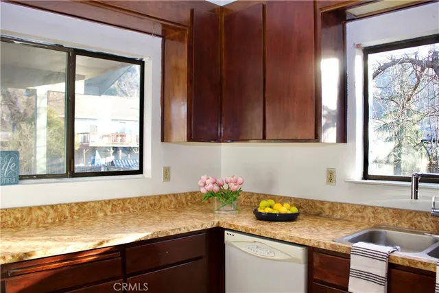 a kitchen with granite countertop white cabinets and a window