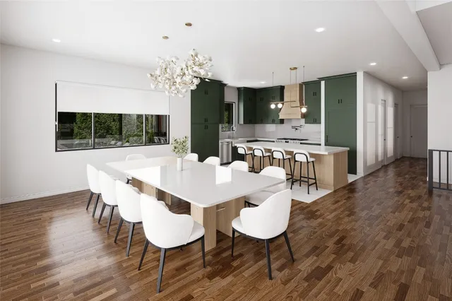 a living room with couches and kitchen view with wooden floor