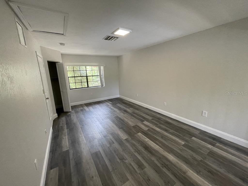 10260 Turkey Lake Road, Unit 150 (A30) Orlando, FL 32819 - Photo 7 of 13 an empty room with wooden floor and windows