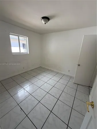 a view of an empty room with wooden floor and a cabinet