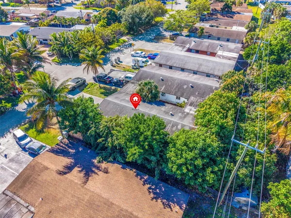 an aerial view of residential houses with swimming pool and lawn chairs