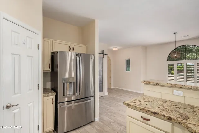 a kitchen with stainless steel appliances granite countertop a refrigerator and a stove top oven