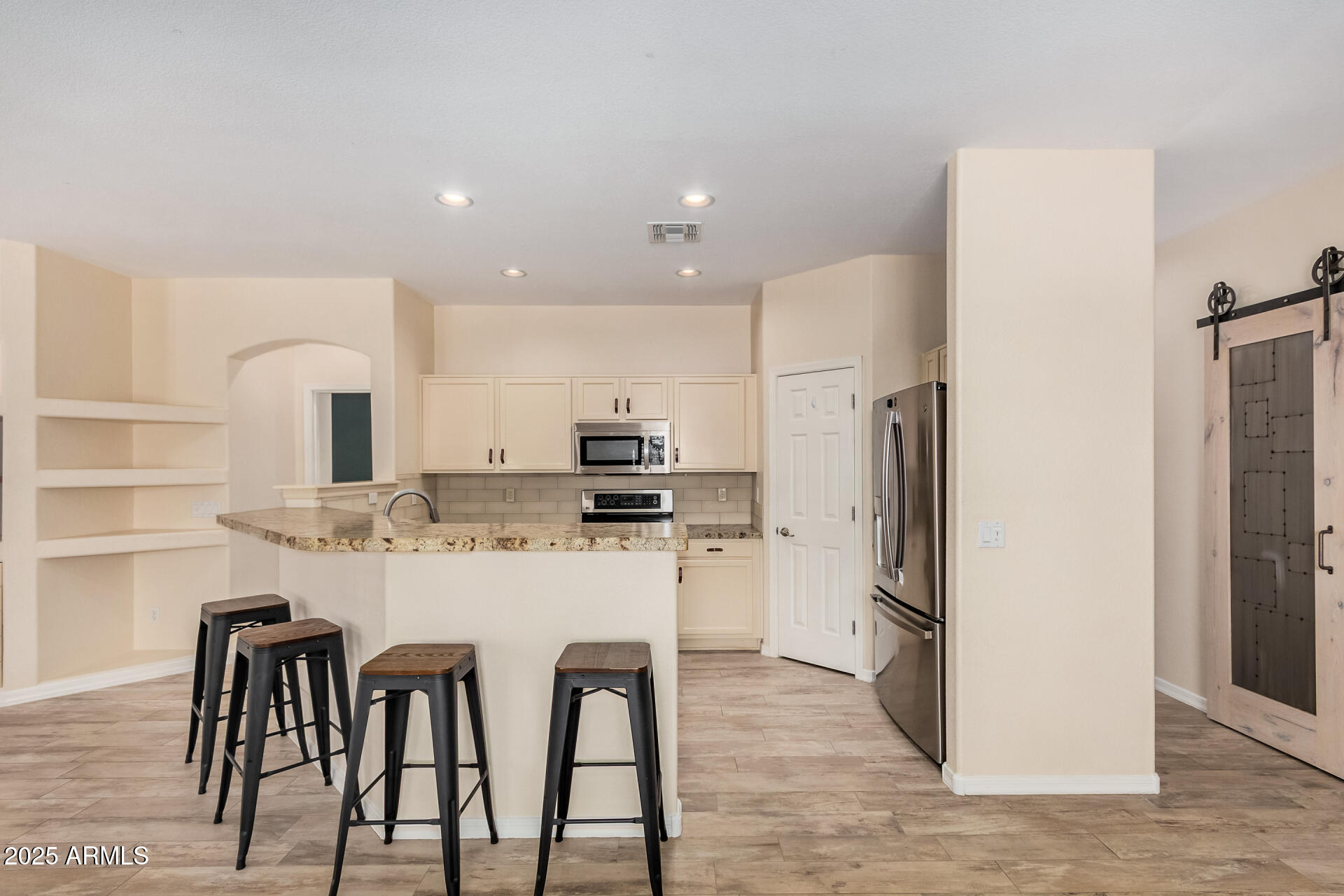 3047 East Fremont Road Phoenix, AZ 85042 - Photo 10 of 36 a kitchen with stainless steel appliances kitchen island granite countertop a refrigerator and a stove top oven