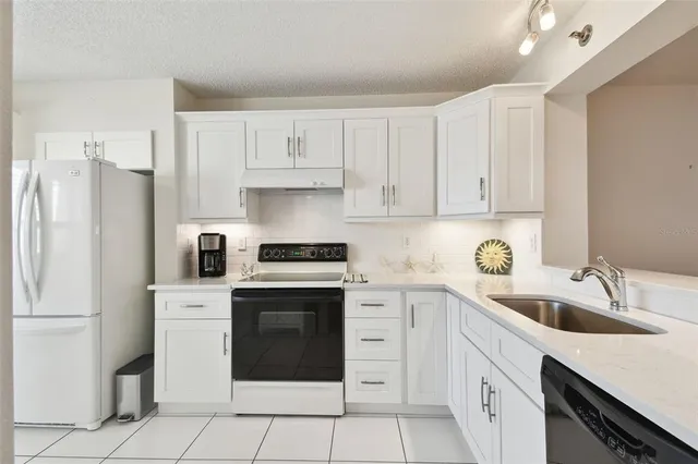 a kitchen with white cabinets and appliances