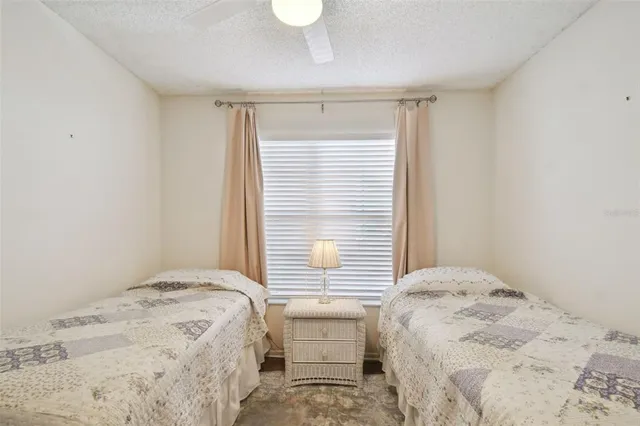 a bedroom with a bed and two window