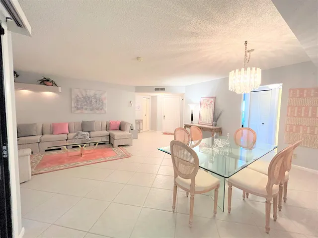 a living room with furniture a dining table and a painting on the wall