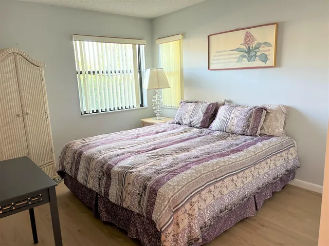 a bedroom with two beds and a dresser with wooden floor