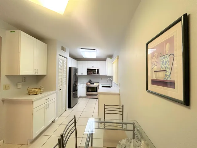 a kitchen with stainless steel appliances kitchen island granite countertop a refrigerator and cabinets