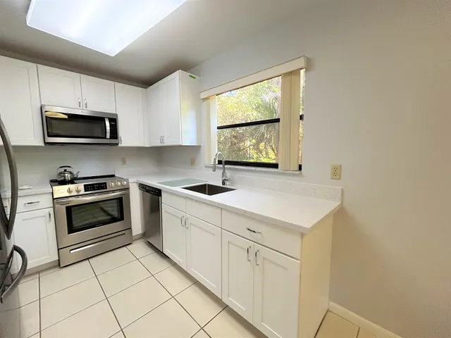 a kitchen with stainless steel appliances a sink a stove a microwave and cabinets