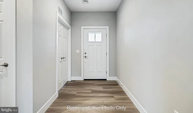 a view of a hallway with wooden floor and closet