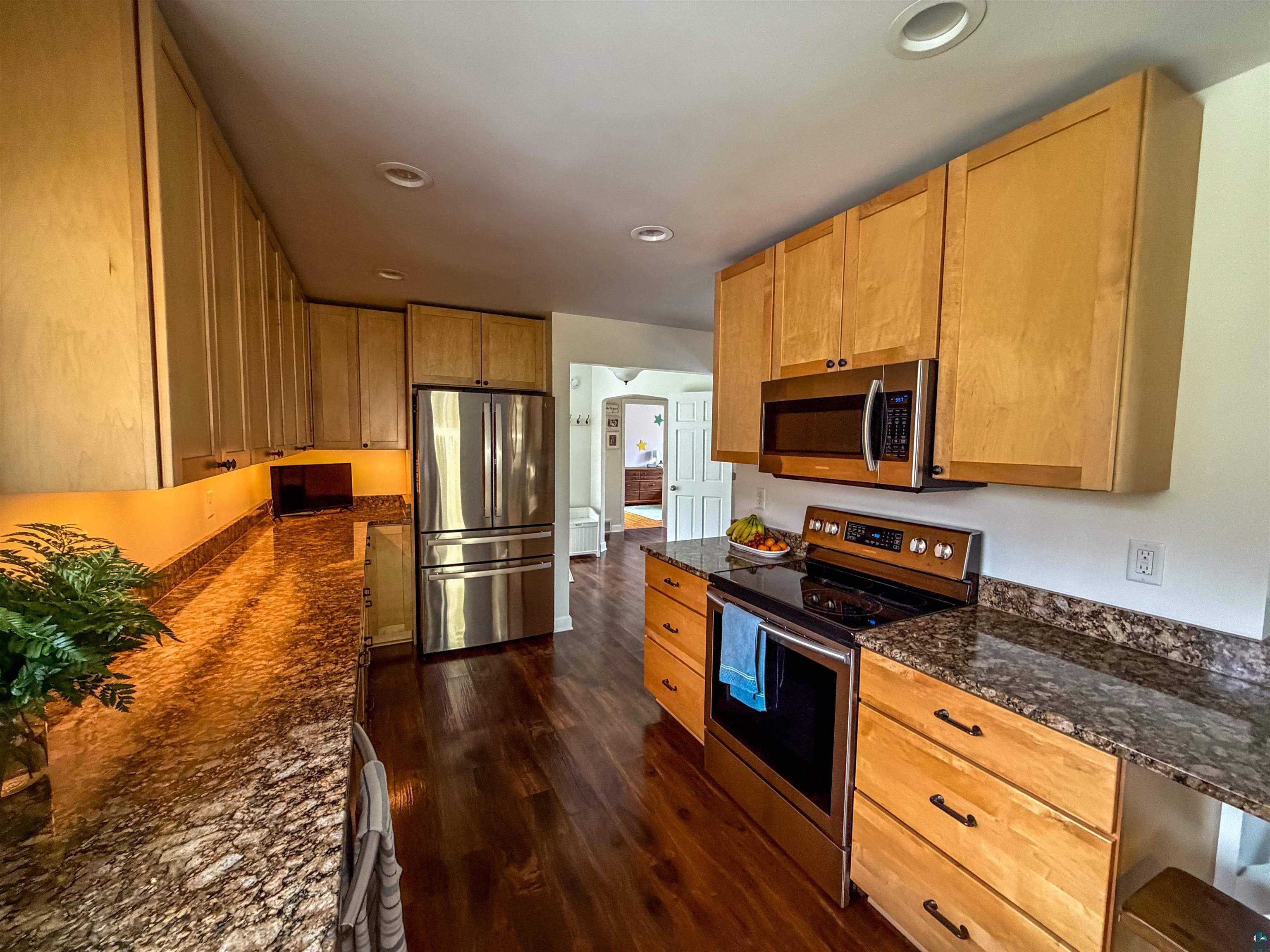 3704 Greysolon Road Duluth, MN 55804 - Photo 5 of 51 Kitchen featuring light wood cabinetry, stainless steel appliances, dark wood-finish flooring, recessed lighting, and speckled countertops