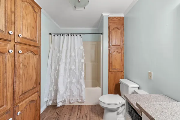 a bathroom with a granite countertop sink toilet and shower