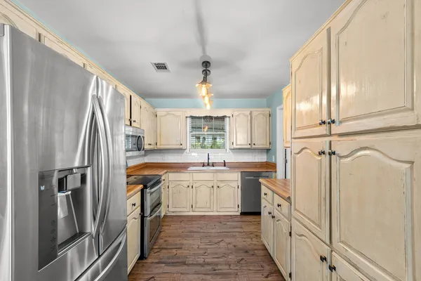 a kitchen with white cabinets stainless steel appliances and window