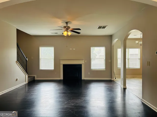 a view of an empty room with a window and wooden floor