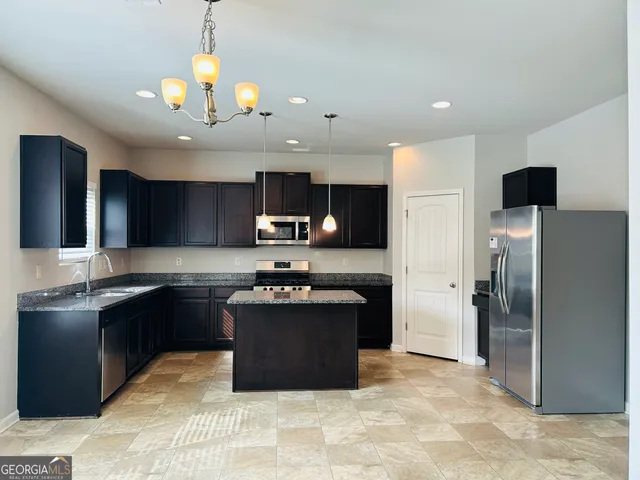 a kitchen with kitchen island granite countertop stainless steel appliances and a counter space