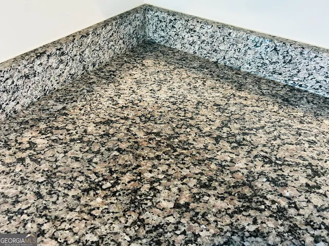 a kitchen with kitchen island granite countertop wooden floor and a refrigerator