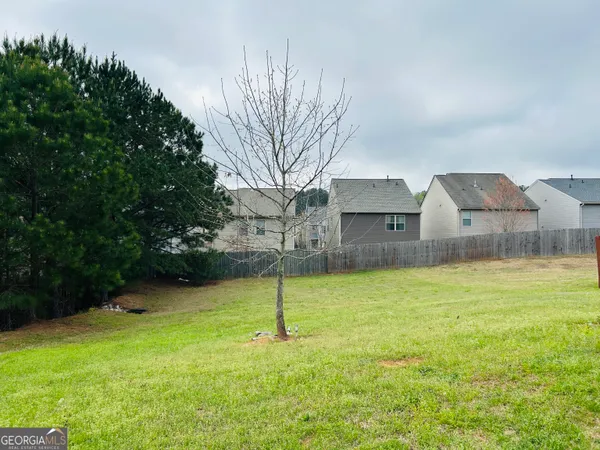 a front view of a house with a yard and large trees