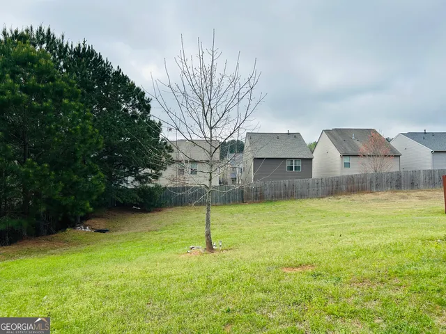 a front view of a house with a yard and large trees