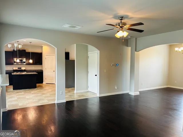 a view of a livingroom with wooden floor and a ceiling fan