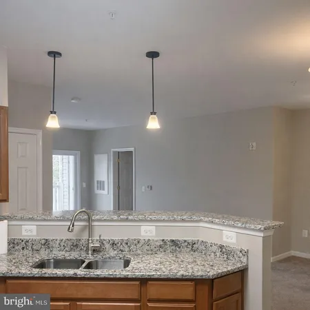 a view of a kitchen with a sink and chandelier