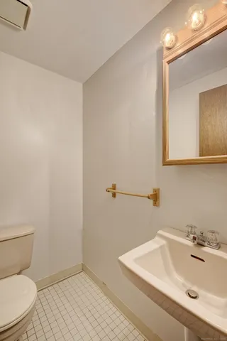 a bathroom with a sink mirror and toilet