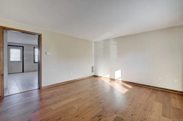 a view of empty room with wooden floor