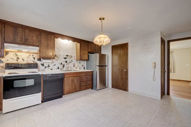a kitchen with stainless steel appliances granite countertop a refrigerator and a stove top oven