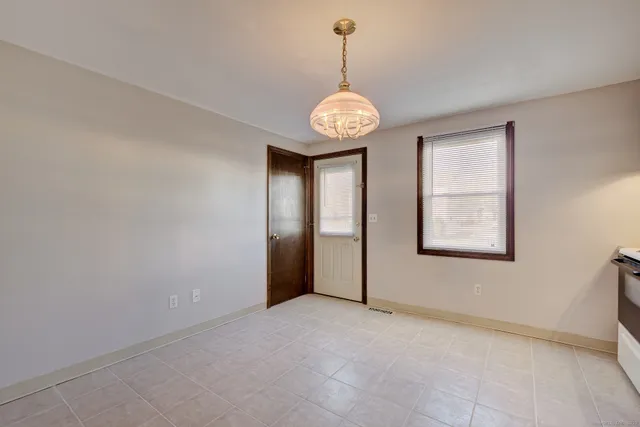 a view of a hallway with a chandelier fan and windows