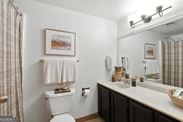a bathroom with a double vanity sink toilet and a mirror