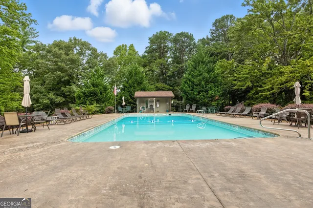 an aerial view of residential house with outdoor space and trees all around
