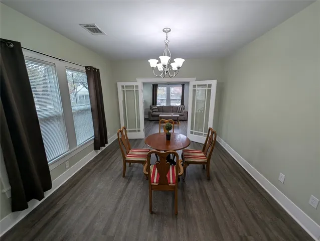 a view of a dining room with furniture a chandelier and wooden floor