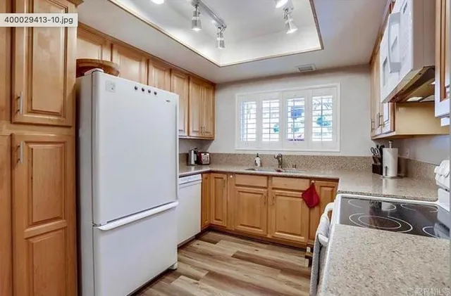 a kitchen with granite countertop a refrigerator and a sink
