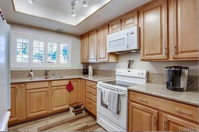 a kitchen with a sink window and cabinets