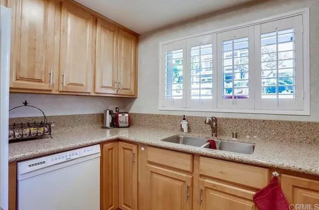 a kitchen with stainless steel appliances granite countertop a sink a refrigerator and cabinets