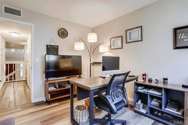 a view of a workspace with furniture and wooden floor