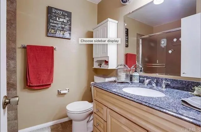 a bathroom with a granite countertop toilet sink and a mirror