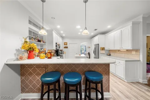a kitchen with stainless steel appliances a dining table chairs sink and cabinets