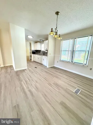 a view of a kitchen with wooden floor and windows