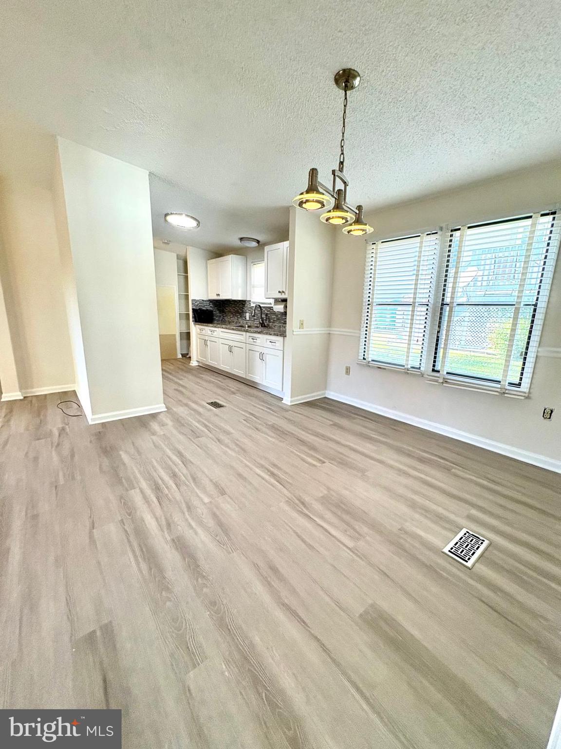 7714 Walnut Lane Mount Airy, MD 21771 - Photo 11 of 42 a view of a kitchen with wooden floor and windows