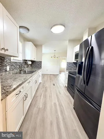 a large kitchen with a stove a sink dishwasher and a refrigerator