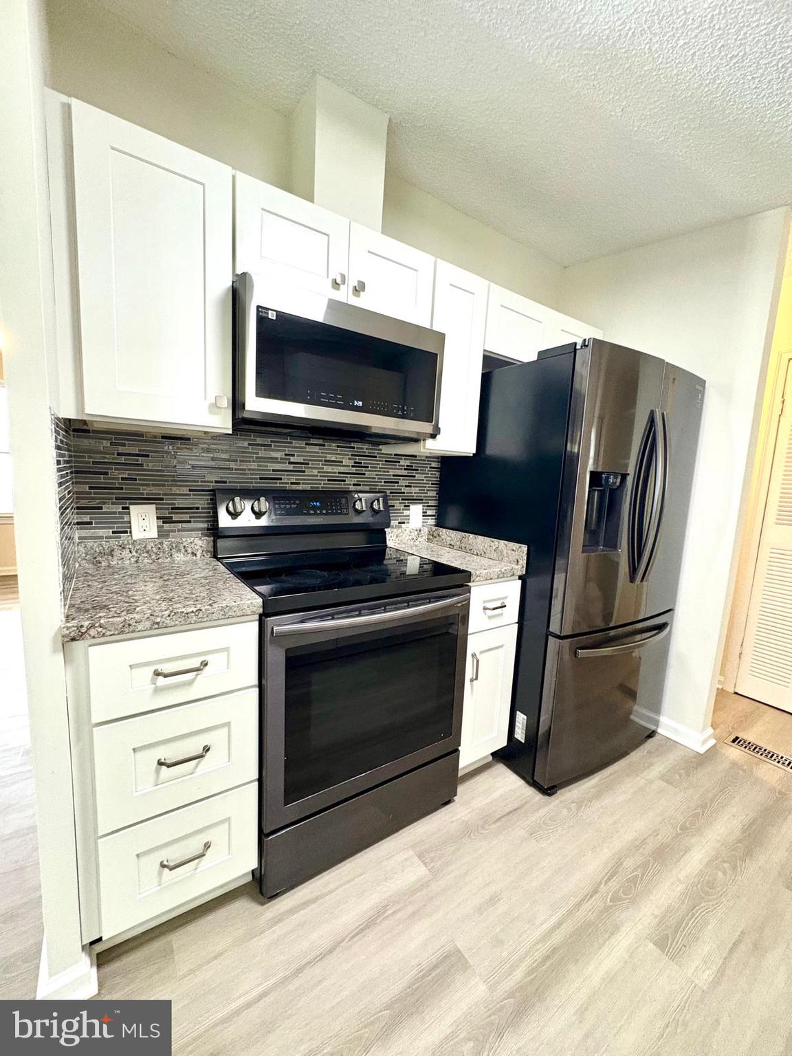 7714 Walnut Lane Mount Airy, MD 21771 - Photo 14 of 42 a kitchen with stainless steel appliances a stove microwave and refrigerator