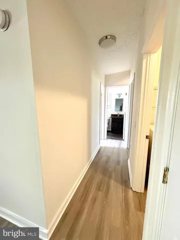 a view of a hallway with wooden floor and closet