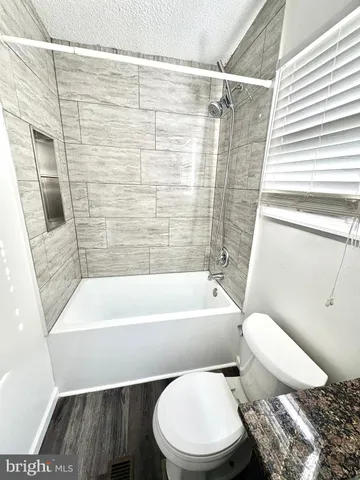 a white toilet sitting next to a bath tub and a shower